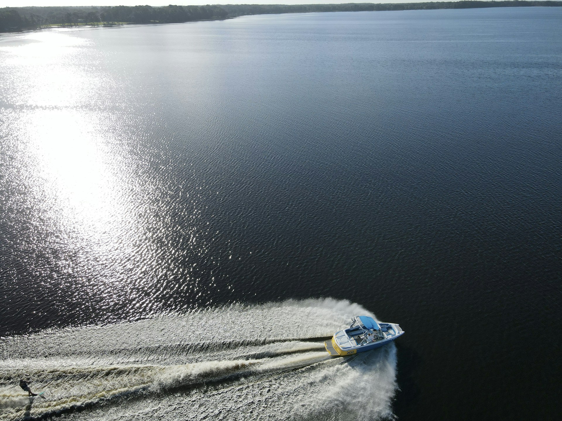 A motorboat carving a wake across blue lake water